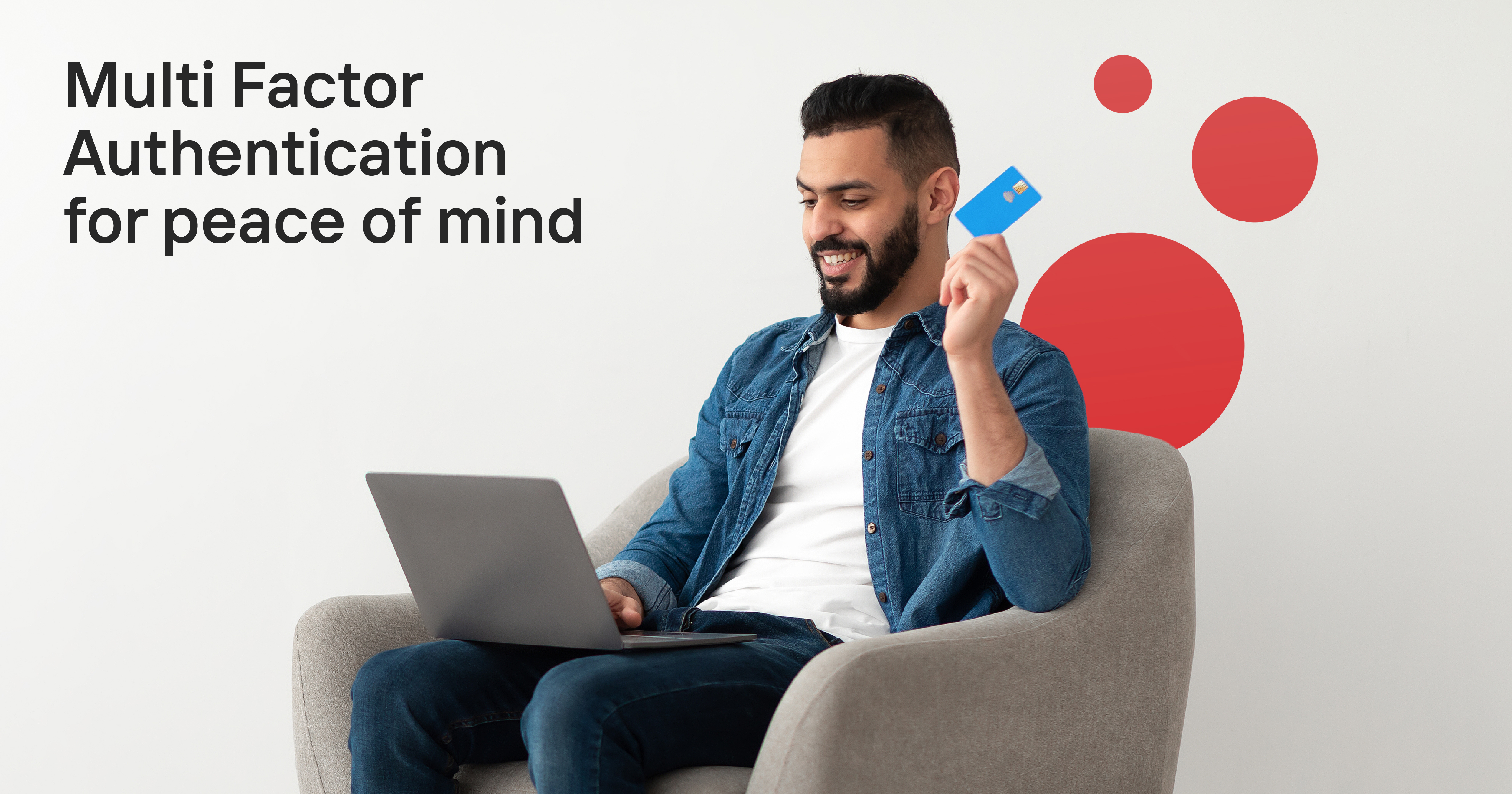 a man sitting in front of a laptop with a bank card in his hand