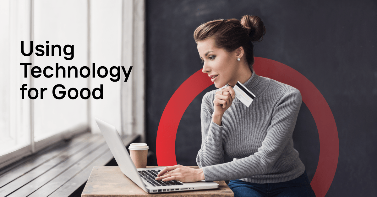 woman holding payment card in front of laptop